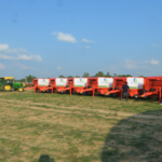 a row of farm equipment parked in a field