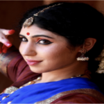 A woman dressed in traditional Indian attire poses gracefully for a photograph, showcasing vibrant colors and intricate designs.